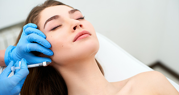 aesthetic treatment with a woman receiving an injection to enhance facial features in a clinical setting rejuvenation beauty procedures