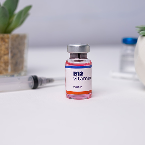 b12 vitamin injection bottle with syringe and plant in background promoting two health benefits